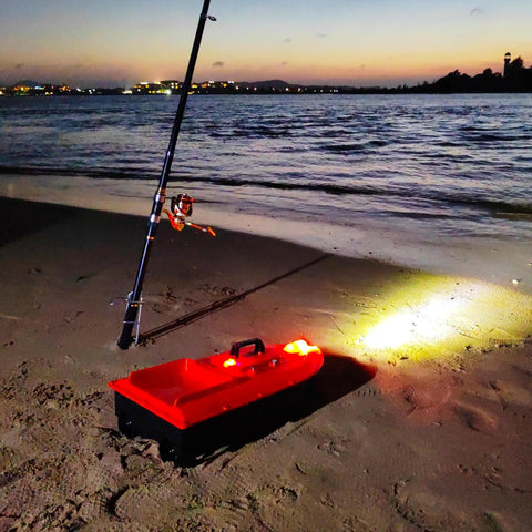 High Speed RC Saltwater Bait Boat For Beach Fishing With Waterproof Hull And GPS Auto Return on night beach with fishing rod.