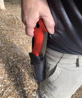 Close-up of a hand holding a 7 Inch Folding Pruning Saw With Fast Cut Razor Tooth Blade in a protective sheath.