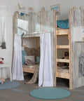 Children's room with a bunk bed decorated with rustic wooden paneling, draped curtains, and pastel accents for a cozy look.