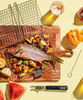 Grill Basket Set For Barbecue Lovers holding fish and vegetables on a wooden board with lemon and skewers nearby.