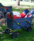 Beast Heavy Duty Folding Utility Wagon With All Terrain Wheels And Telescoping Handle loaded with picnic items in Denim Blue