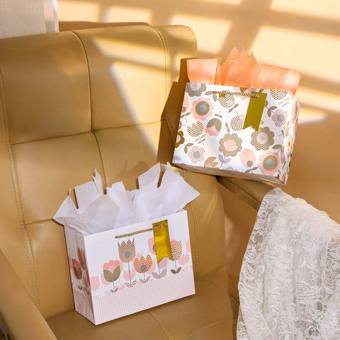 Two Pack 9 Inch Flower Gift Bags With Tissue Paper Featuring Tulip Floral Design Perfect For Mother's Day Gifts Birthdays Bridal Showers Easter And More Gift Wrapping Made Easy on chair.