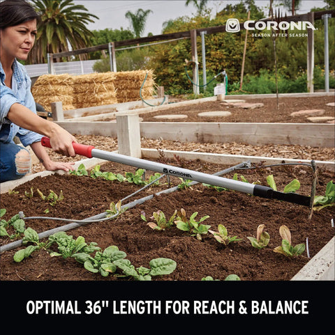 Person using Extended Reach Hoe And Cultivator All In One Garden Tool For Weed Busting And Soil Loosening with long ergonomic handle.