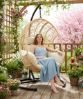 Woman relaxing in Outdoor Hanging Egg Chair With Stand And Rain Cover, All Weather PE Wicker Swing Chair With Waterproof Cushions