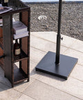 Outdoor Umbrella Base 42Lbs With Stainless Steel Tube, Heavy Duty Cement-Filled Square Metal Stand on patio with furniture
