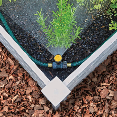 Adjustable Spike Sprinkler Bundle With Three Sprinklers And Two 15 Foot Hoses watering a corner garden bed evenly
