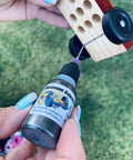 Applying Premium Pinewood Derby Graphite Powder with Easy Application Tip to Car Wheels for Top Speeds