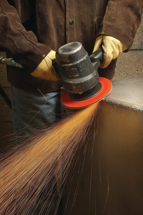 Worker using angle grinder with Fiber Disc 987C 36 Plus Grit Metal Grinding Disc, sparks flying during metal grinding.
