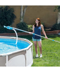 Woman using Deluxe Above Ground Pool Maintenance Kit With Vacuum For 800 GPH Flow Rate 110 Inch Telescoping Pole Wall Brush cleaning pool