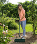 Woman using Rolling Lawn Aerator With Ergonomic Handle And Sand Or Stone Fill 18 Inch Wide Dethatching Tool in garden