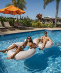 Motorized Pool Tube Float For Adults Pro 3.0 With 66W Motor Joystick Steering Phone Holder And Cup Holder Blue Finish Lets You Glide Turn And Cruise Across The Water All Day with people relaxing in pool.