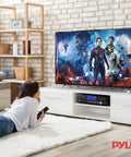 Living room setup with Four Channel 1000W Bluetooth Power Amplifier With Built In CD DVD Player FM Radio USB, beneath mounted TV.
