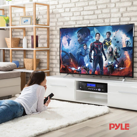 Living room setup with Four Channel 1000W Bluetooth Power Amplifier With Built In CD DVD Player FM Radio USB, beneath mounted TV.