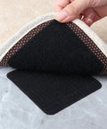 Hand placing 10 Pack Rug Grippers Non Slip Pads For Hardwood Floors Keep Rugs From Curling And Slipping Instantly Easy To Apply