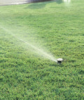 Low Gallonage Pop Up Impact Lawn Sprinkler with Adjustable 20 to 360 Degree Pattern and 26 to 36 Feet Spray Distance in operation on lawn