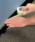 Masking Tape For Office And Home Projects With Strong Adhesive 0.70 Inch By 54.6 Yard Easy Apply Great For Labeling Mounting And Bundling Everyday Use On Clean Surfaces being applied along carpeted floor