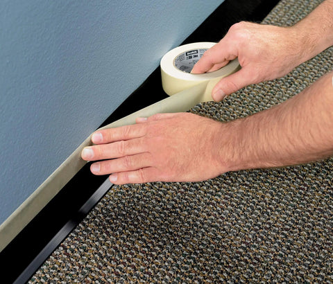 Applying Economy Masking Tape Three Quarters Inch By Sixty Yards General Purpose Crepe Paper Backing to baseboard edge
