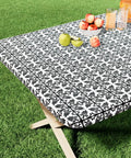 Snug Fit Elastic Fitted Vinyl Table Cover For 6 Foot Tables, Non Slip Waterproof Flannel Backed Plastic Tablecloth, Stain Proof, Ideal For Picnics, Camping, Outdoor Events, Black 30x72 Inches on a wooden table outdoors with fruit