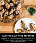 Chicken wings on a plate and in a bowl with herbs, air fried using Digital Air Fry Pro Countertop Oven With Extended Height And XL Capacity.