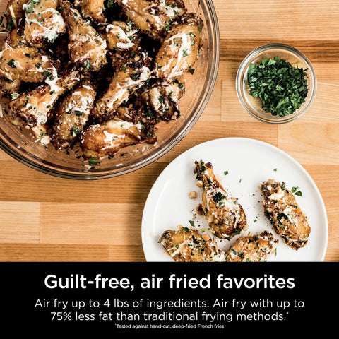 Chicken wings on a plate and in a bowl with herbs, air fried using Digital Air Fry Pro Countertop Oven With Extended Height And XL Capacity.