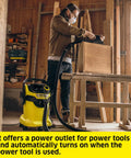 Man using WD 5 P Shop Vacuum 6.6 Gal Wet Dry Vacuum Cleaner With 33 Ft Reach in a workshop