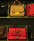 Shelf with designer handbags organized using 8 Pack Acrylic Shelf Dividers for Closet Organization, keeping items neat.