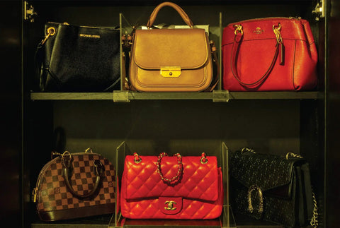 Shelf with designer handbags organized using 8 Pack Acrylic Shelf Dividers for Closet Organization, keeping items neat.