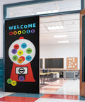 Classroom entrance with a gumball-themed 'Welcome Grades' sign featuring student names in colorful circles.
