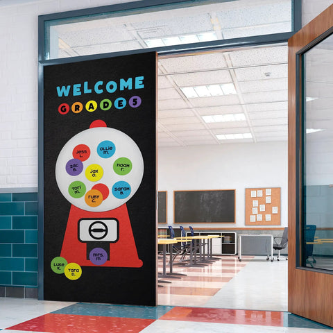 Classroom entrance with a gumball-themed 'Welcome Grades' sign featuring student names in colorful circles.
