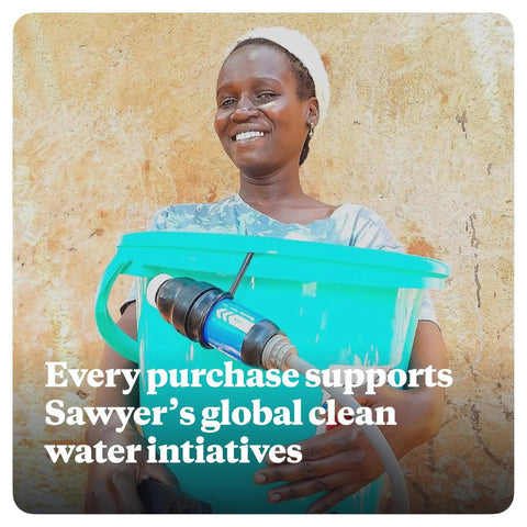 Smiling person holding a blue water bucket with Palm Sized Mini Water Filtration System SP128 Blue attached for clean water access.
