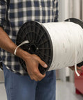 Person holding spool of MT1500 Extreme TrueTape Webbing 1/2 In By 3000 Ft, 1250 Lb Tensile Strength, Heavy Duty PET Webbing