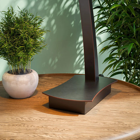 Base of Wright 1 Light Table Lamp in Oil Rubbed Bronze Finish on wooden table, plants in background, home office decor