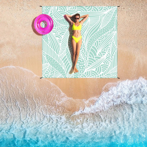 Beach Day Essential Huge Family Sized Beach Blanket Waterproof Sandproof Quick Dry Outdoor Picnic Mat For 1 To 8 Adults Large 79 By 83 Inches Durable Nylon on sandy beach with person relaxing.