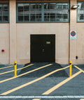 Rock Solid Yard Safety Bollard, Heavy Duty 24 Inch Tall Steel Parking Barrier Post in bright yellow at a driveway entrance.
