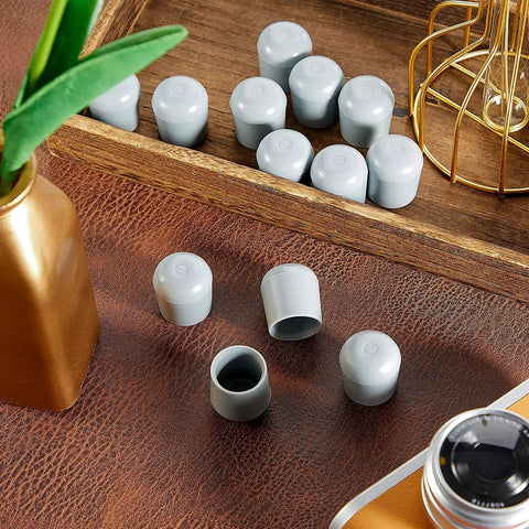 Grey heavy duty plastic chair leg caps from 36 Pack 7 Eighths Inch Folding Chair Leg Caps Heavy Duty Plastic End Caps Non Marring Glides Round Floor Protectors For Hardwood Floors Durable Non Scratch Floor Protection For Homes Offices And Restaurants Grey set displayed on a wooden tray.