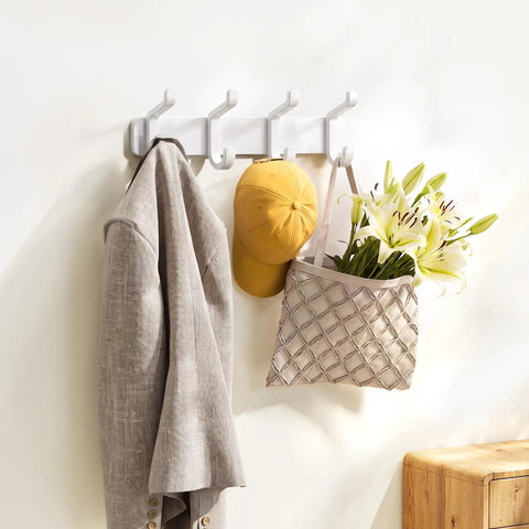 Hella Sturdy Wall Mount Coat Rack Featuring Heavy Duty Double Steel Hooks For Backpack Storage And Rust Proof Coating For Mudroom Storage That Handles Maximum Load Zero Fuss with beige jacket, yellow cap, and floral bag.