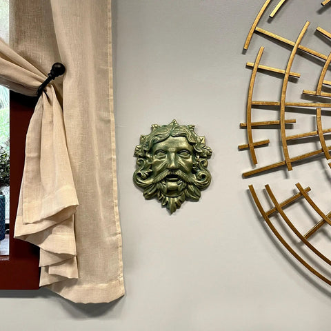 Heavy Duty Cast Iron Celtic Green Man Wall Plaque Sporting A Dead Cool Antiqued Verdigris Finish Standing Ten Inches Tall mounted on wall.