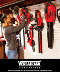 Woman organizing tools on VersaTrack wall system, including corded 6.5 amp string trimmer with 14 inch cutting width.