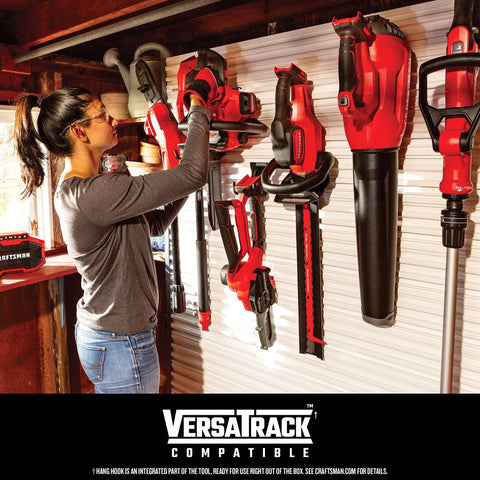 Woman organizing tools on VersaTrack wall system, including corded 6.5 amp string trimmer with 14 inch cutting width.