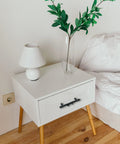 Nightstand with Six Piece Tree Branch Cabinet Handles Set In Black Twig Style installed on drawer by bed.