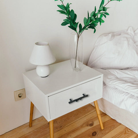 Nightstand with Six Piece Tree Branch Cabinet Handles Set In Black Twig Style installed on drawer by bed.