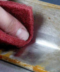 Hand using Roll A VFN 6 Inch By 30 Foot Pro Grade Abrasive Pad Roll for metal finishing and scuffing on metal surface