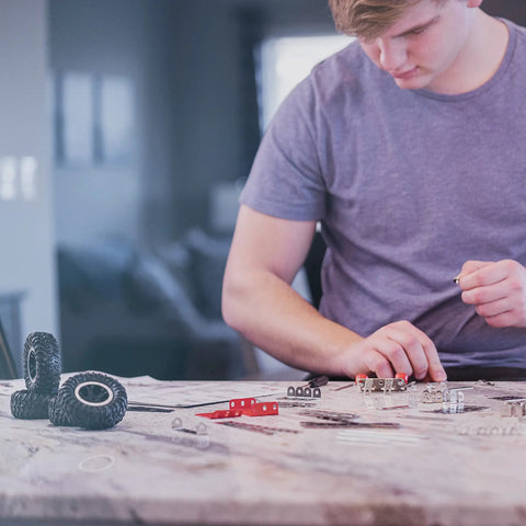 Person assembling Beast Mode Erector Set Metal Model Kit For Adults Teens And Advanced Kids Build Cars Planes And Excavators