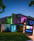 Hand holding smartphone controlling 24 Pack WiFi Smart LED Light Bulbs Color Changing RGB Dimmable illuminating modern house