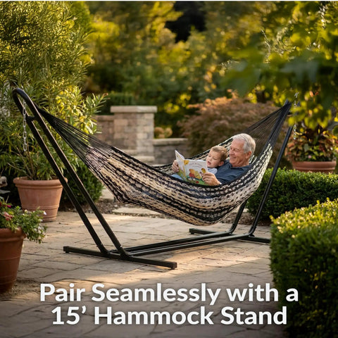 XXL Handwoven Mayan Double Hammock For Outdoor Use With Thick Cord 156 Inch Wide 90 Inch Deep And 625 Pound Capacity Heavy Duty Outdoor Hammock In Black And Natural with two people relaxing on a stand in a garden.