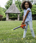 Child playing with Real Feel Toy Leaf Blower That Lights Up And Actually Blows Air Kid Friendly Mini Tool For Ages 3 And Up in yard