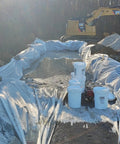 Construction site using Liquid Lock Slurry Absorbent Powder in 5 gallon pail with scoop for solidifying liquid waste