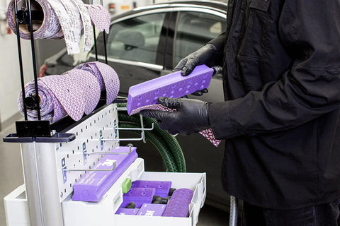 Person holding Hookit Dust Extraction Flexible Sanding Block Kit with four lengths for automotive sanding in workshop