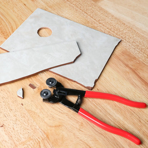 Glass Tile Nippers With Pro Grade Carbide Cutting Wheels And Comfy Grip on wooden surface with cut tile pieces