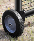 Close-up of an 8 Inch Heavy Duty Gate Wheel on grass, featuring a black rubber tire and gray wheel rim, designed for smooth yard work.